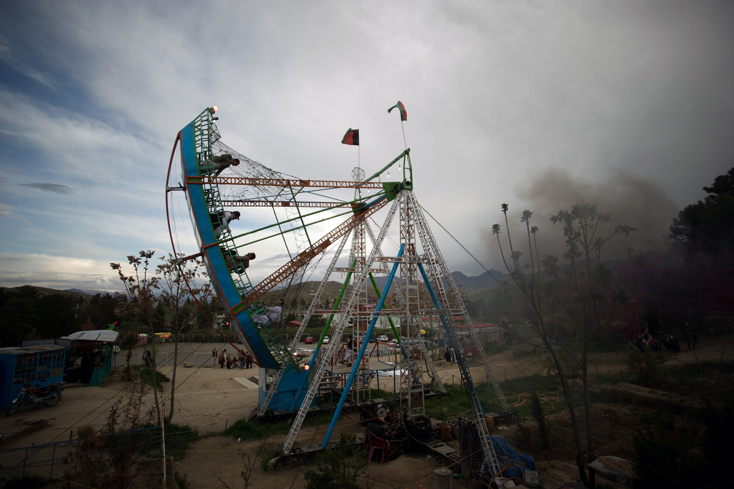 April 27, 2012. Afghans sit on a fairground boat swing ride in Band-e-Qargha Gulestan Park in Kabul.