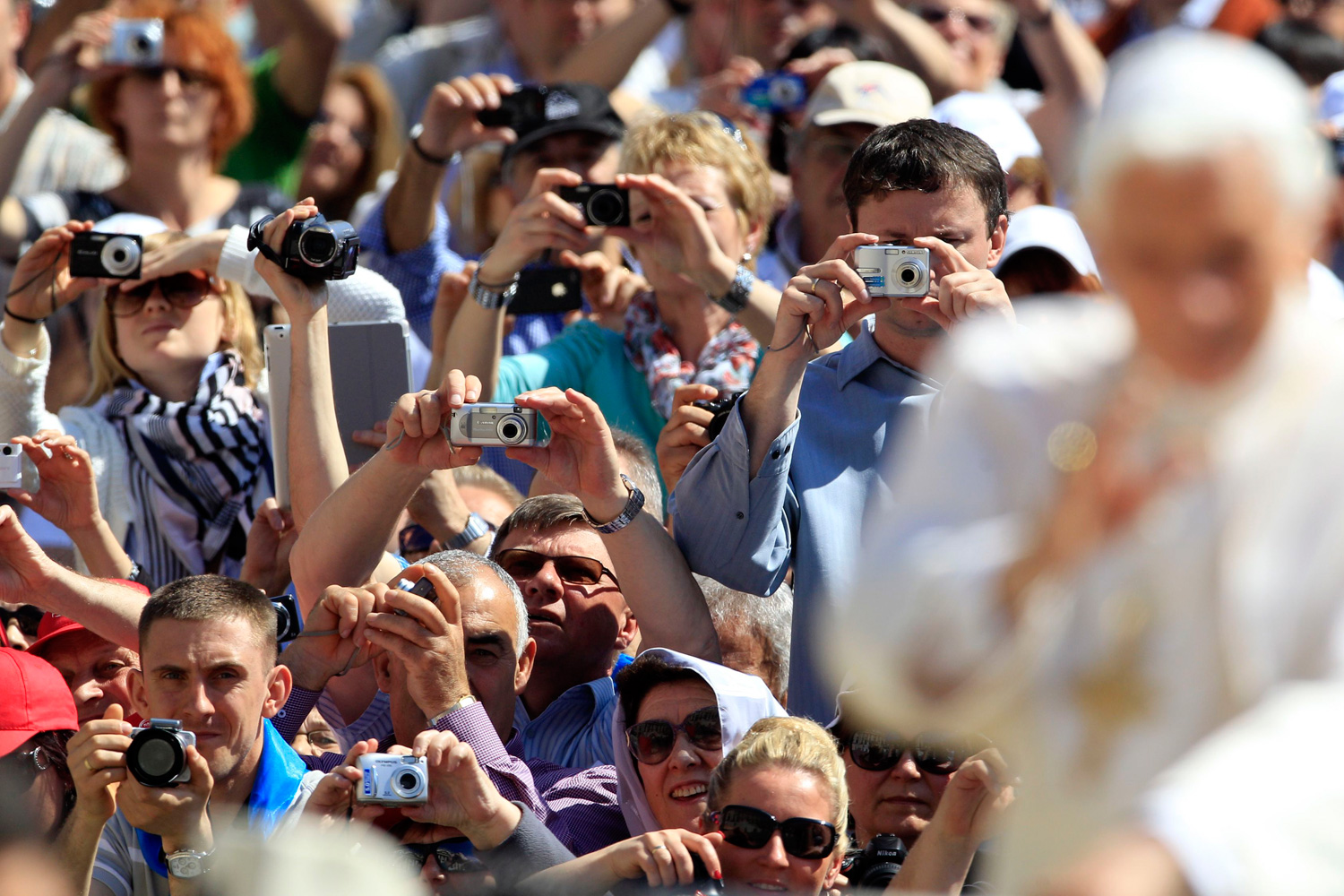May 2, 2012. Visitors take pictures of Pope Benedict XVI during his weekly audience in Saint Peter's Square at the Vatican.
