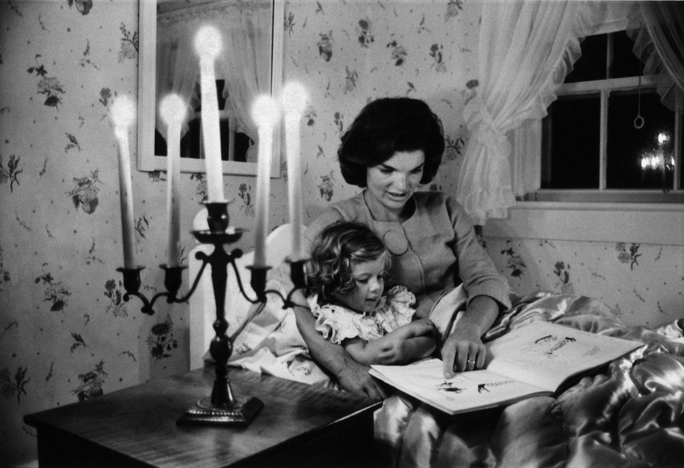 Jackie Kennedy reads to her daughter, Caroline, in Hyannis Port, Mass., in 1960.