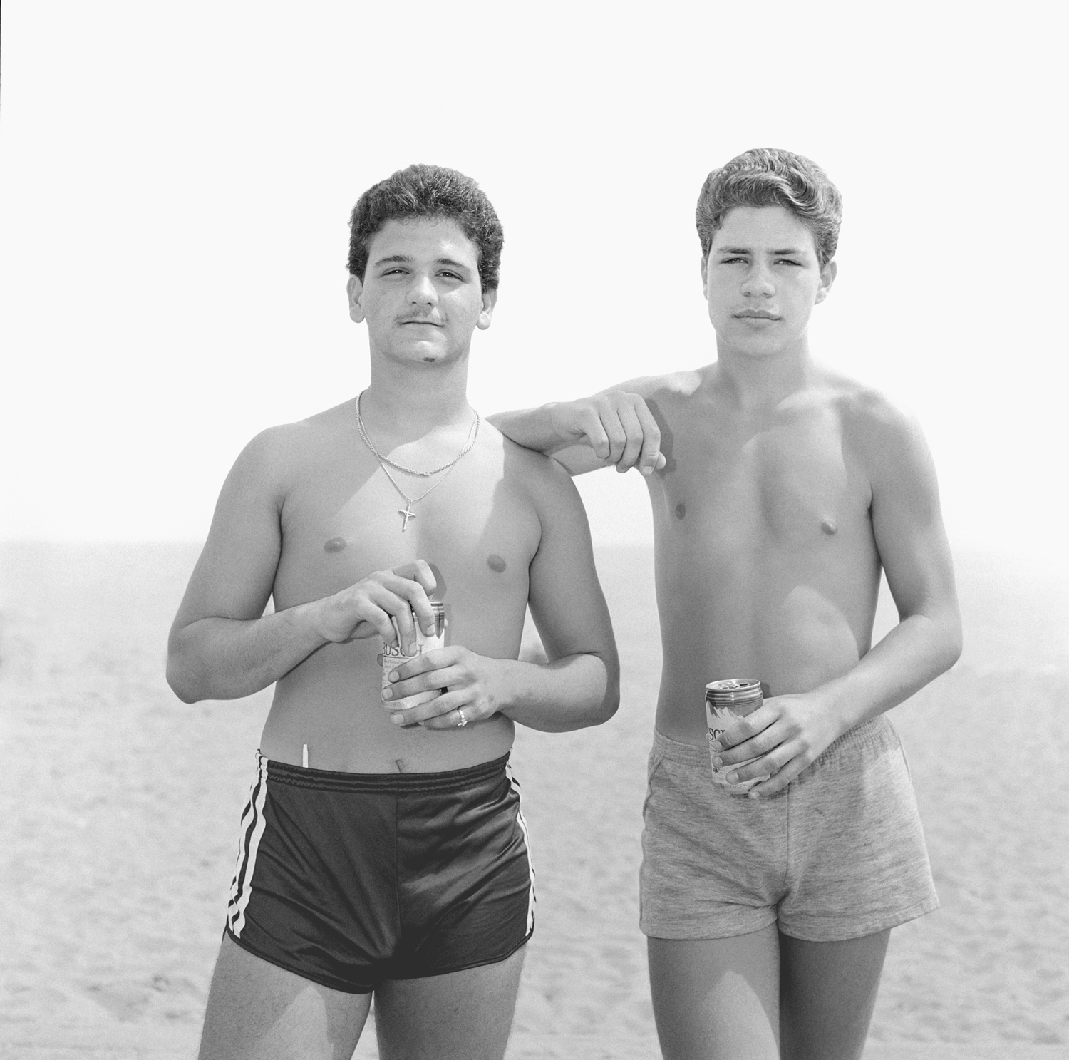 Two young men with beer at the beach.