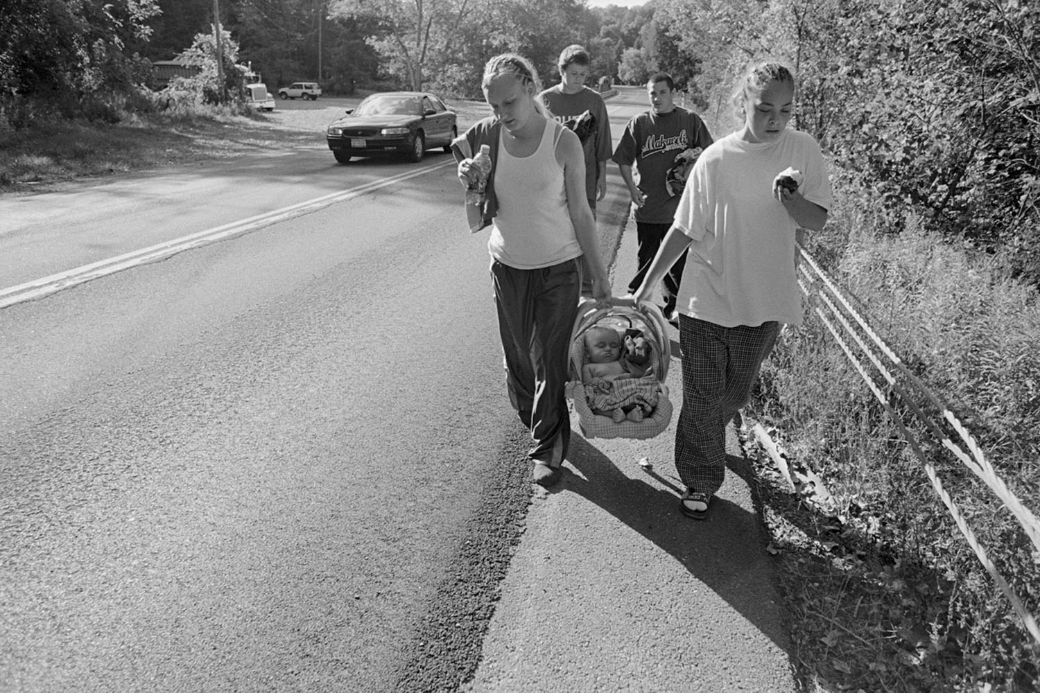 Kayla and Sabrina and their boyfriends take turns carrying Donny down Route 2 to the local swimming hole. Donny is part of an extended family of teens from the girls' North Troy neighborhood.