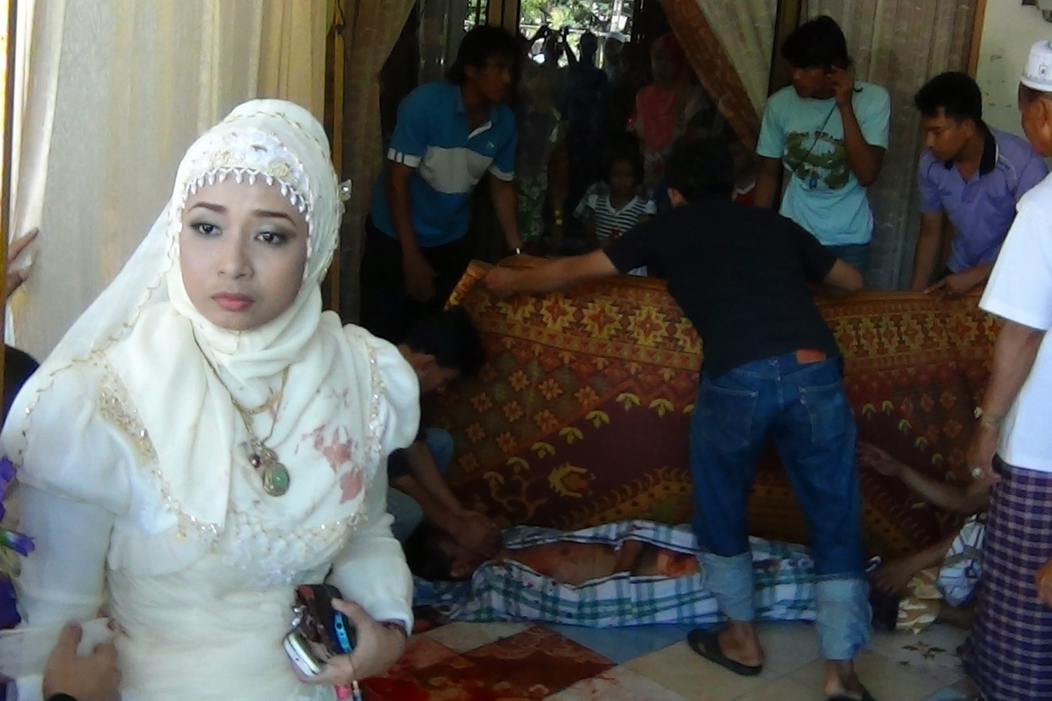June 10, 2012. Bride Nurasatilah Masae (L) standing in front of her bridegroom who was shot dead during their wedding in the Muslim majority province of Pattani, southern Thailand.