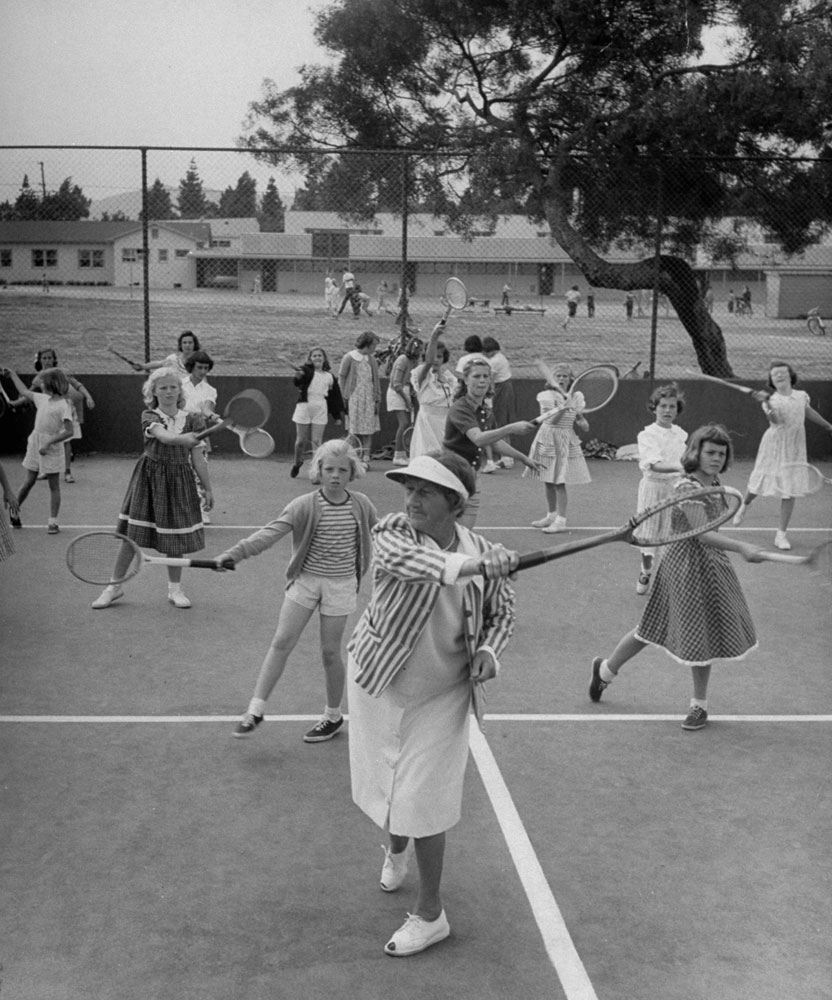 Tennis veteran Florene Sutton shows the correct forehand motion to school children at a weekly clinic in 1950.