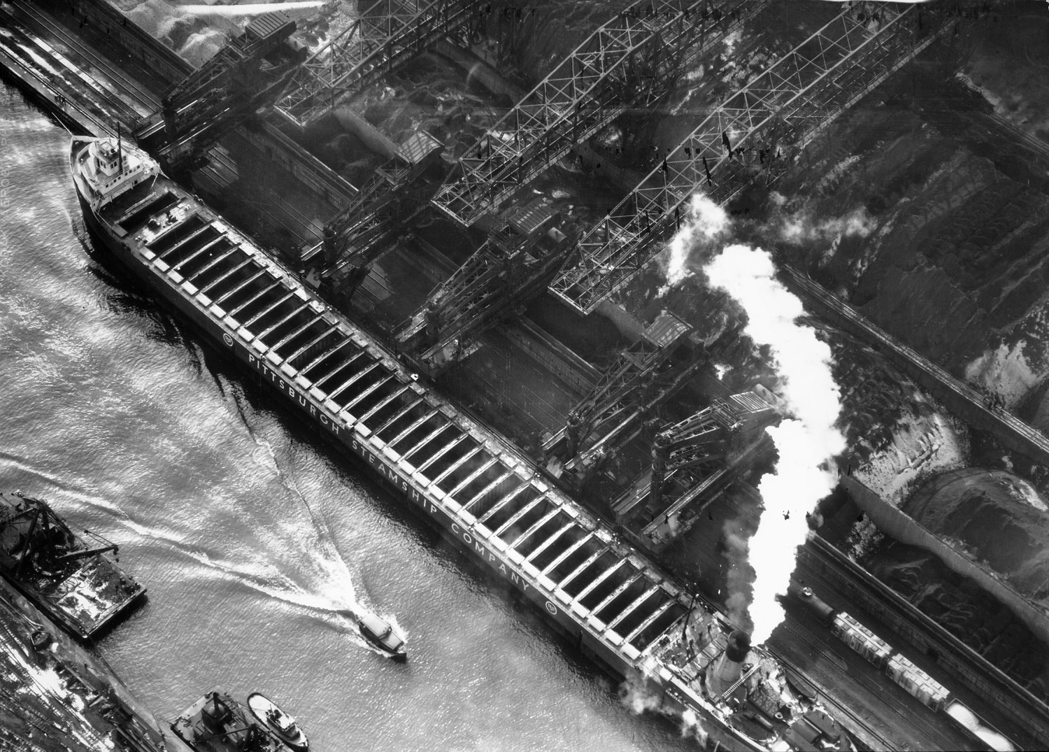 Pittsburgh Steamship Co. ship carrying ore to US Steel plant. Gary, Indiana, photographed from a helicopter, 1952.