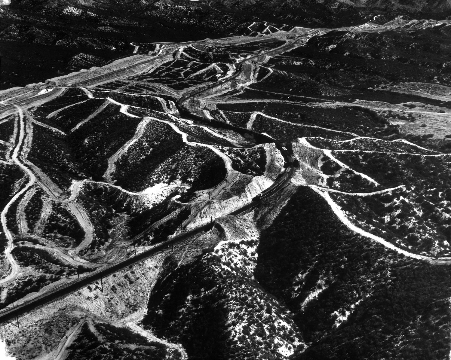 Freight train traveling through the El Cajon Pass outside San Diego, Calif., photographed from a helicopter, 1952.