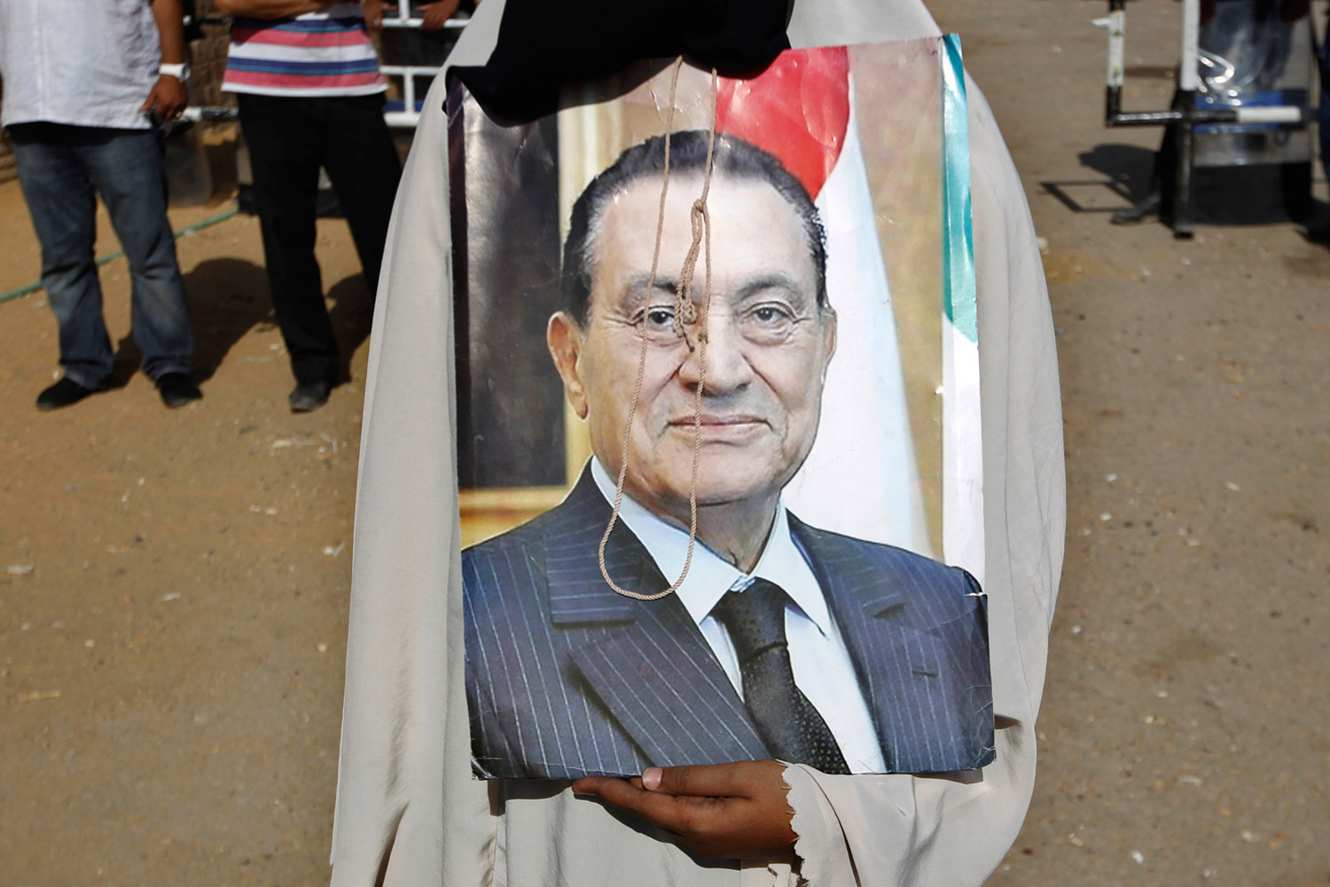 June 2, 2012. A supporter of deposed president Hosni Mubarak holds his picture after a court sentenced him to life in prison, outside the police academy where the court is located in Cairo.