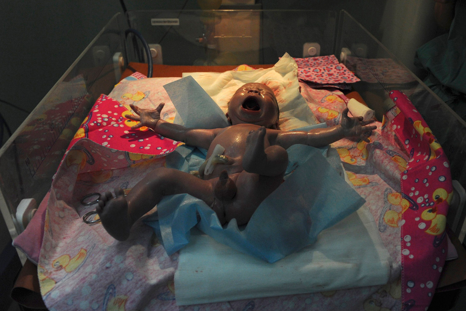 June 4, 2012. A newborn baby stretches in a hospital bassinet after being cleaned following a caesarean section at a hospital in Shaya county, Xinjiang Uighur Autonomous Region, China.