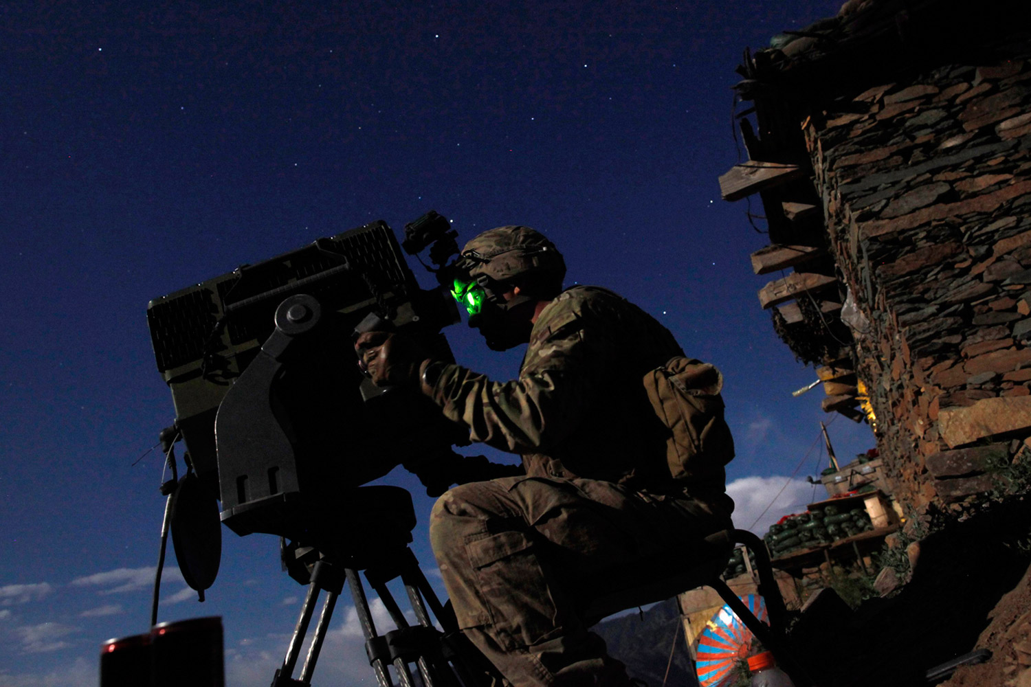 June 5, 2012. A soldier from the United States Army's Charlie Company, 1-12 Infantry, 4th Brigade, 4th Infantry Division keeps watch at night at Observation Post Mustang in Afghanistan's Kunar Province.