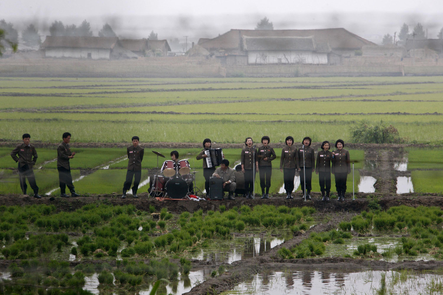 June 6, 2012. A music group performs on a path amid fields to greet the farmers at Hwanggumpyong Island, near the North Korean town of Sinuiju and the Chinese border city of Dandong.