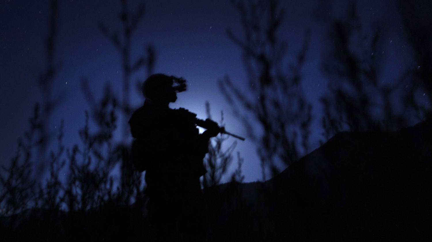 A soldier from the U.S. Army's Alpha Company, 1-12 Infantry, 4th Brigade, 4th Infantry Division, guards an LZ at night at COP Pirtle-King in Afghanistan