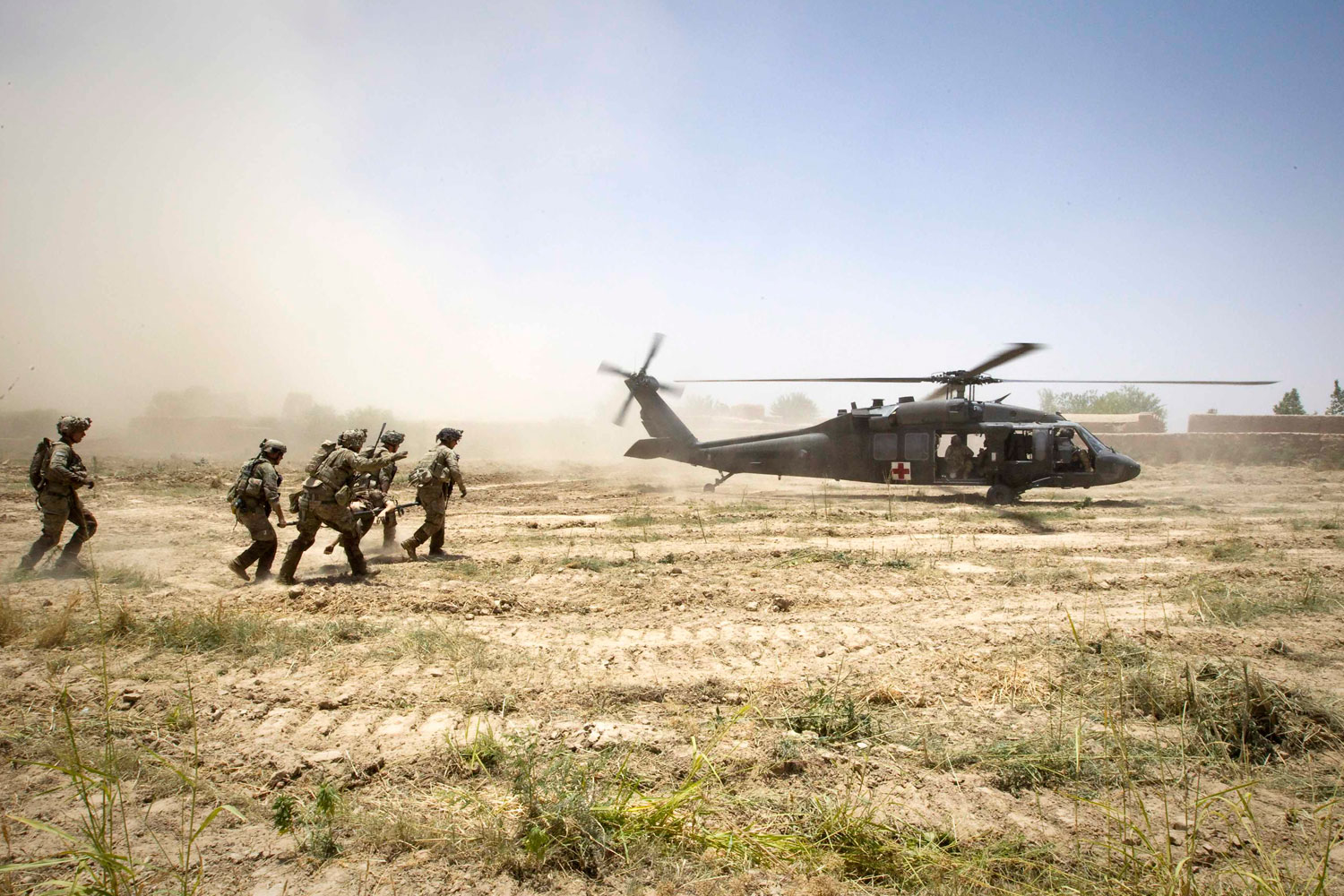June 12, 2012. U.S. Army soldiers carry their comrade wounded at patrol by an improvised explosive device (IED) towards a Blackhawk Medevac helicopter in southern Afghanistan.