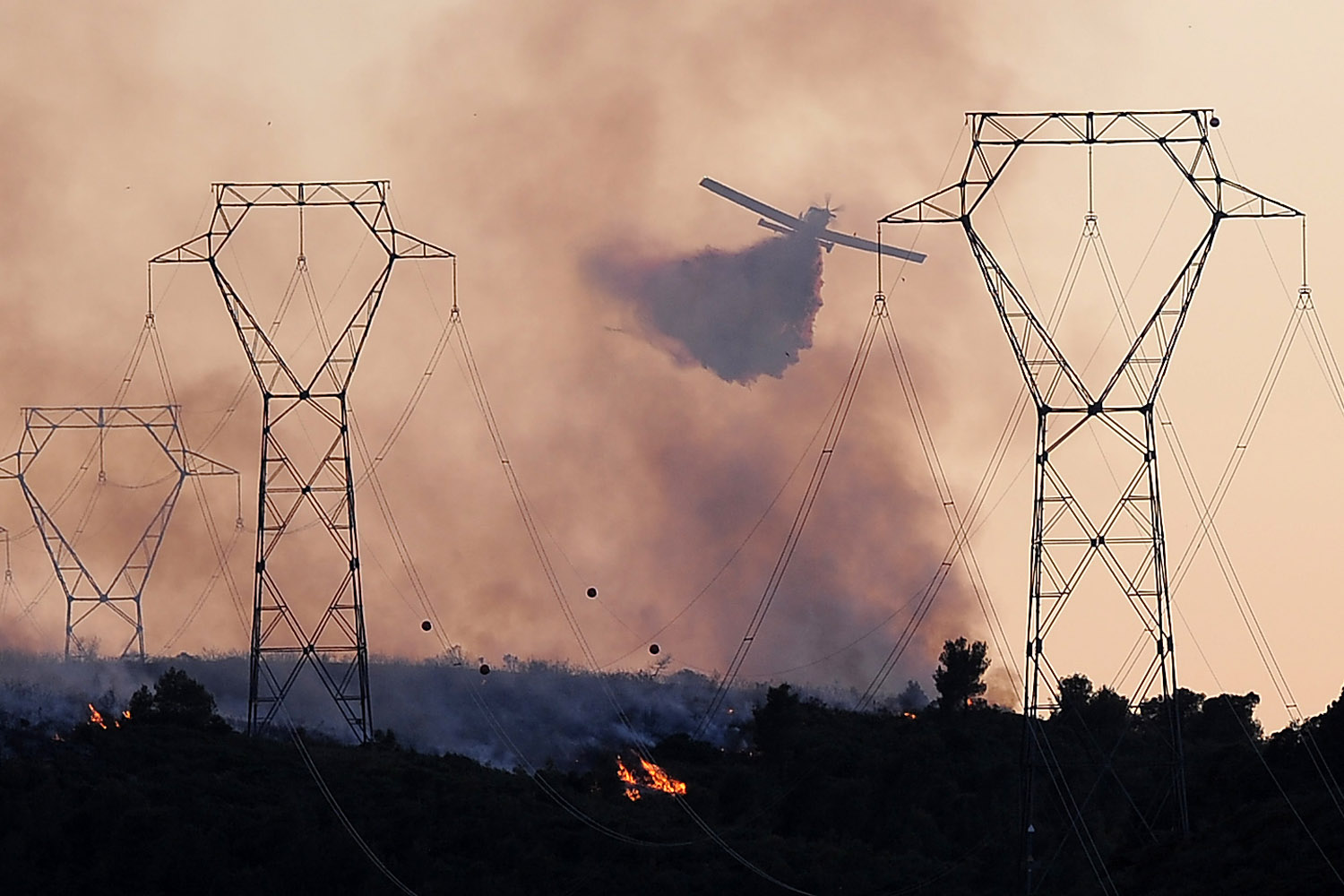 A helicopter drops water on a wild fire burning near the village of Vilanova i la Geltru.