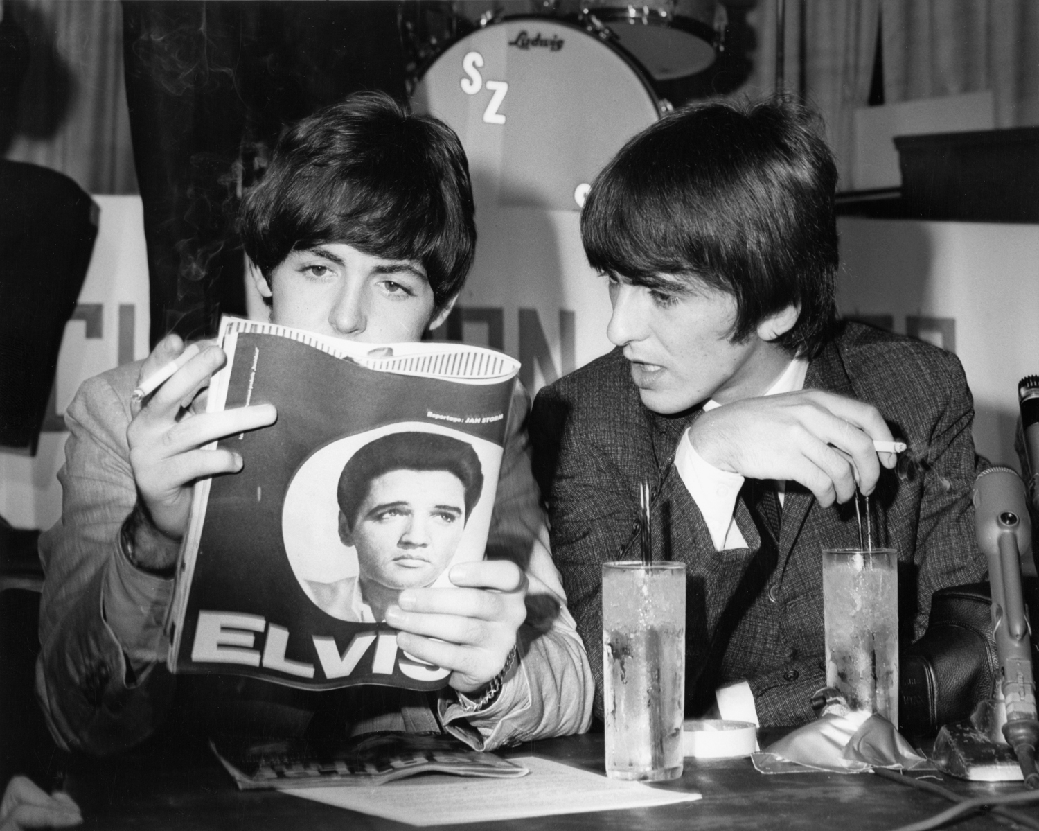 Paul McCartney and George Harrison reading a magazine, 1965.