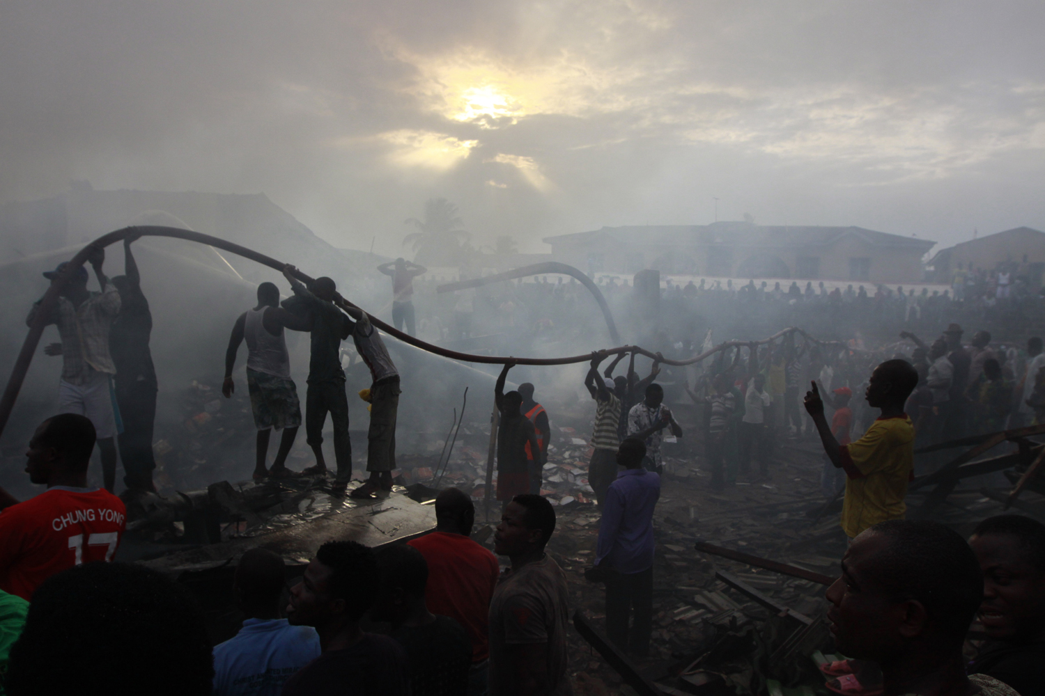 June 3, 2012. People gather at the site of a plane crash in Lagos, Nigeria.