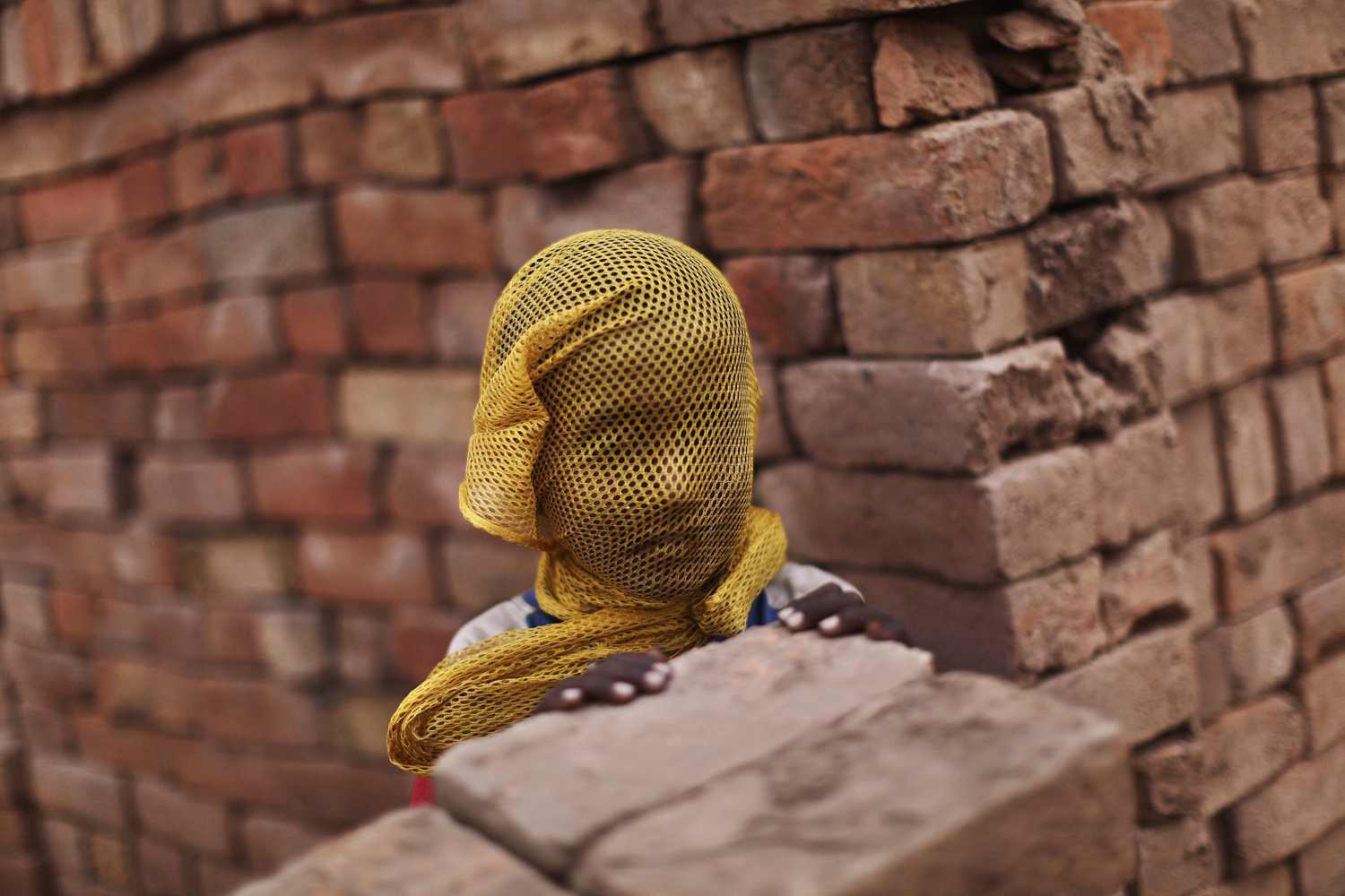 June 6, 2012. A Pakistani boy who lives near by a brick factory covers his face with a scarf to avoid a sand storm, on the outskirts of Islamabad.