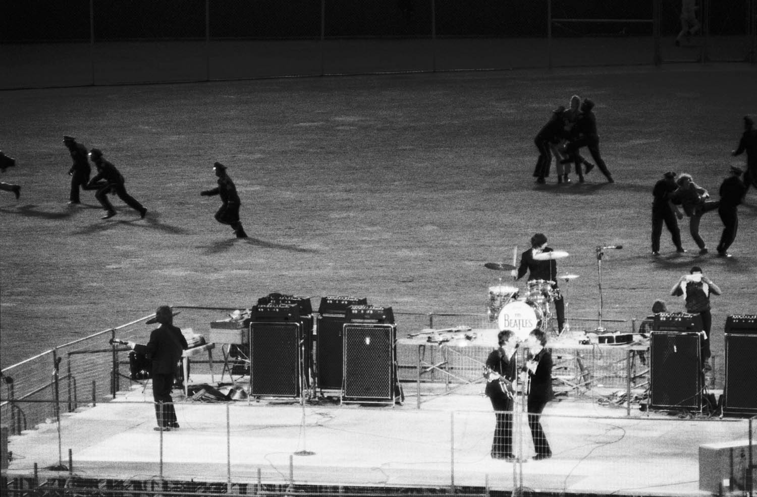 Policemen clear the field of enthusiastic fans as The Beatles perform on a bandstand in Candlestick Park, San Francisco, California, Aug 30, 1966.