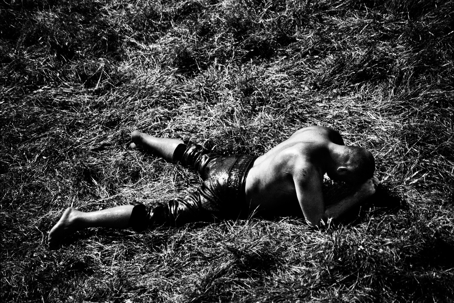 A wrestler lies defeated on the field.