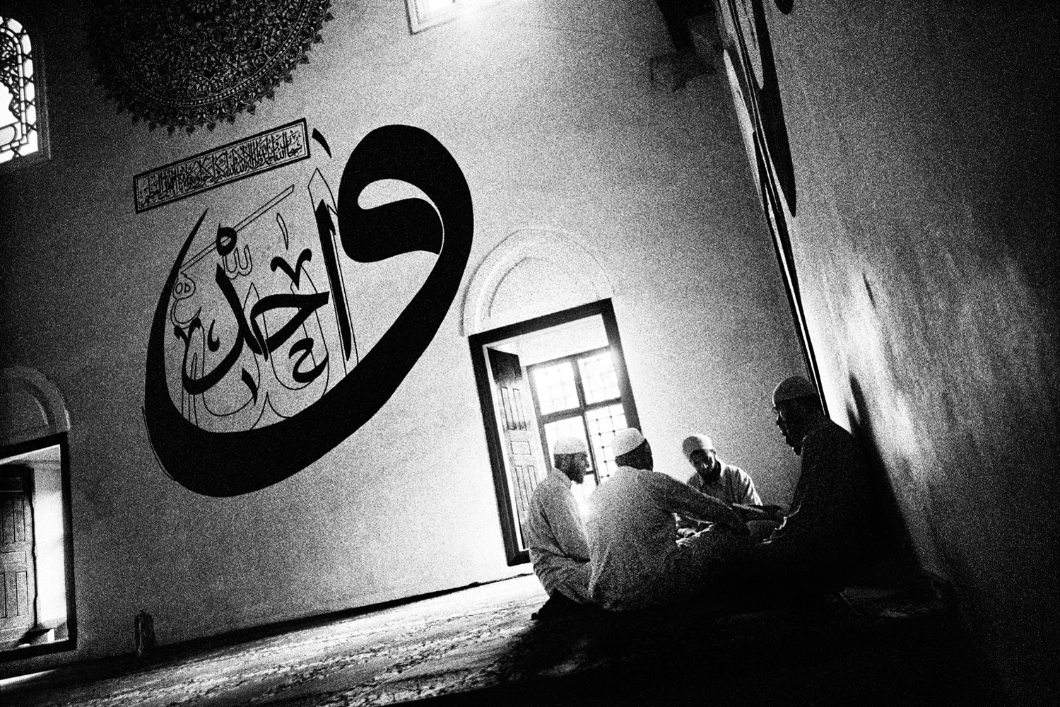 Men gather after prayer at the Old Mosque. Finished in 1414, it is famous for its large-scale wall calligraphy.