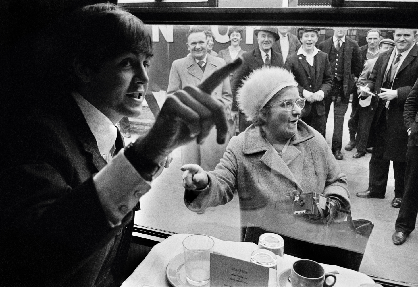 The Beatles during filming of 'A Hard Days Night'. The Beatles film was primarily shot on a moving train. Fan recognizing Paul McCartney. London, England, 1964.