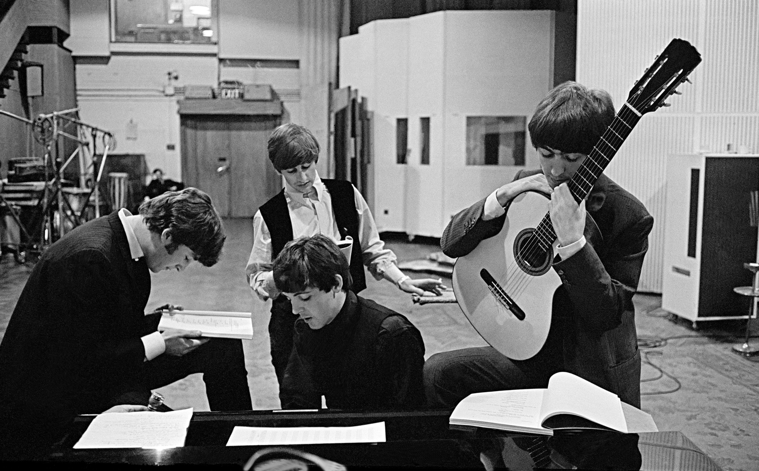 The Beatles in the Abbey Road Studios, where many of their most famous records were made, examining the script of the film 'A Hard Days Night'. London, England, 1964.