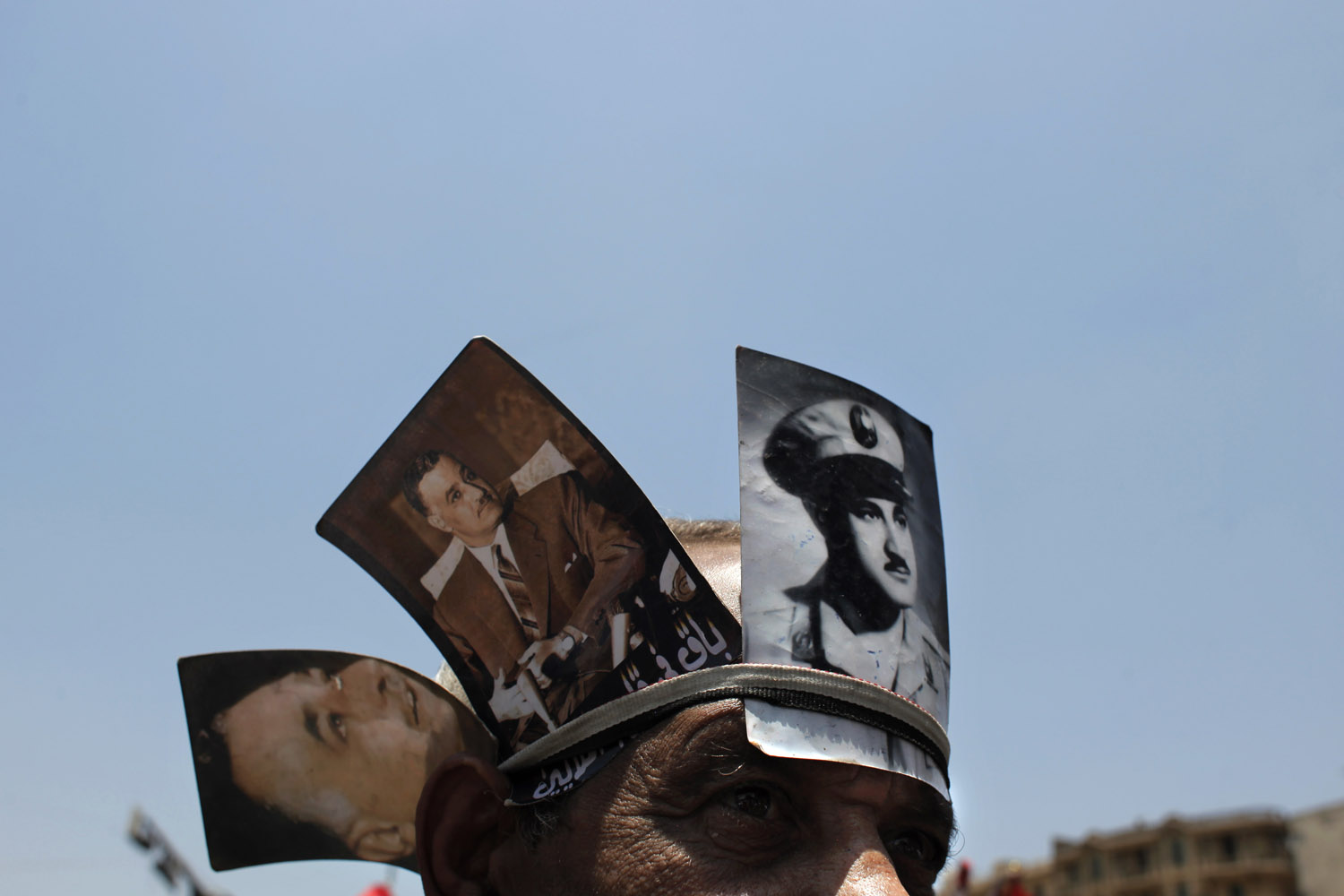 June 8, 2012. An Egyptian protester, wearing pictures of late Egyptian President Gamal Abdel Nasser on his head, attends a demonstration at Tahrir Square, Cairo, Egypt.