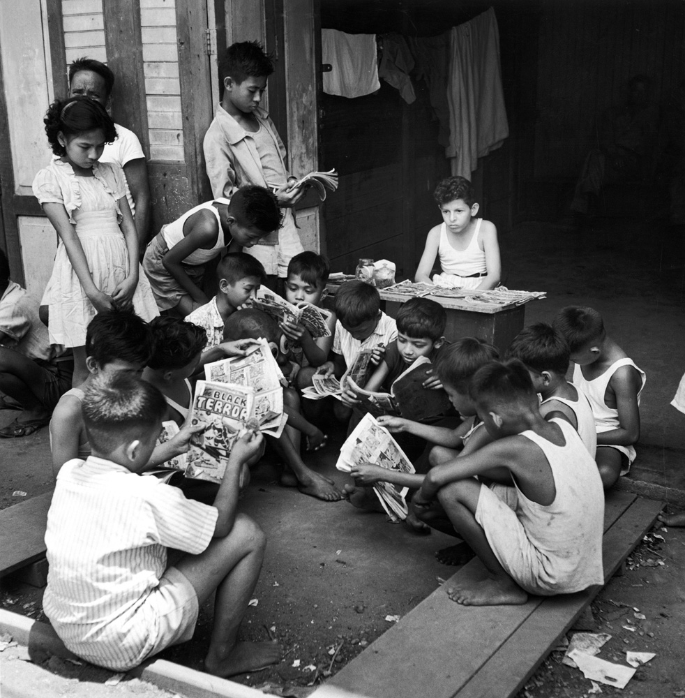 A Turkish boy (center) rents out comic books to local children to support his family in the Philippines in 1945.