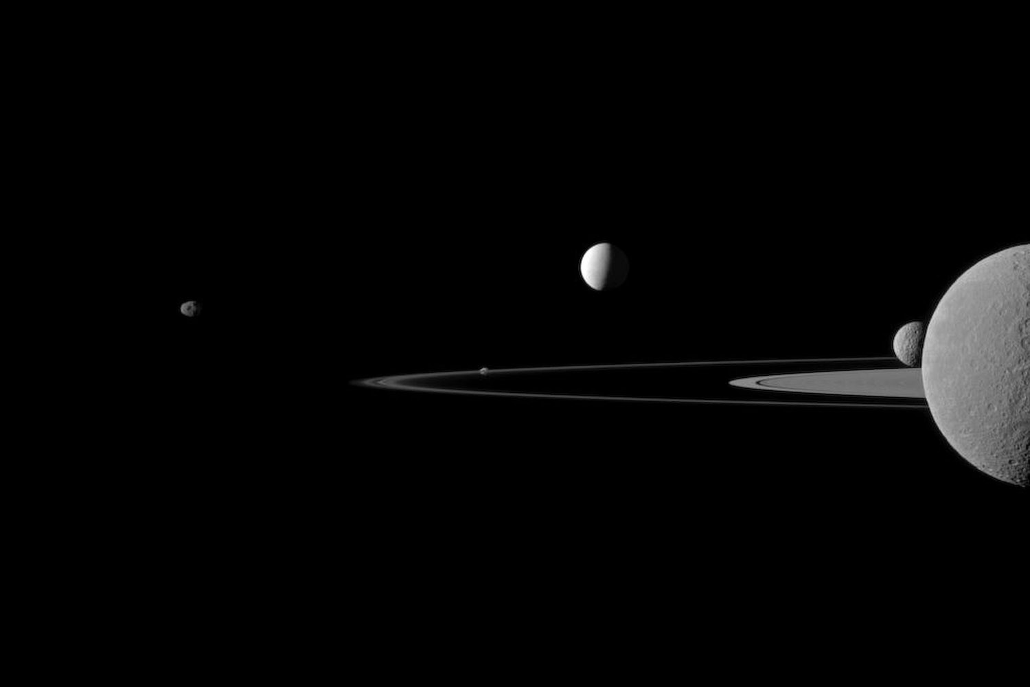 July  16, 2012. An image of Saturn's moons as they orbit the huge planet, created by the Cassini-Huygens mission, a cooperative project of NASA, the European Space Agency and the Italian Space Agency.