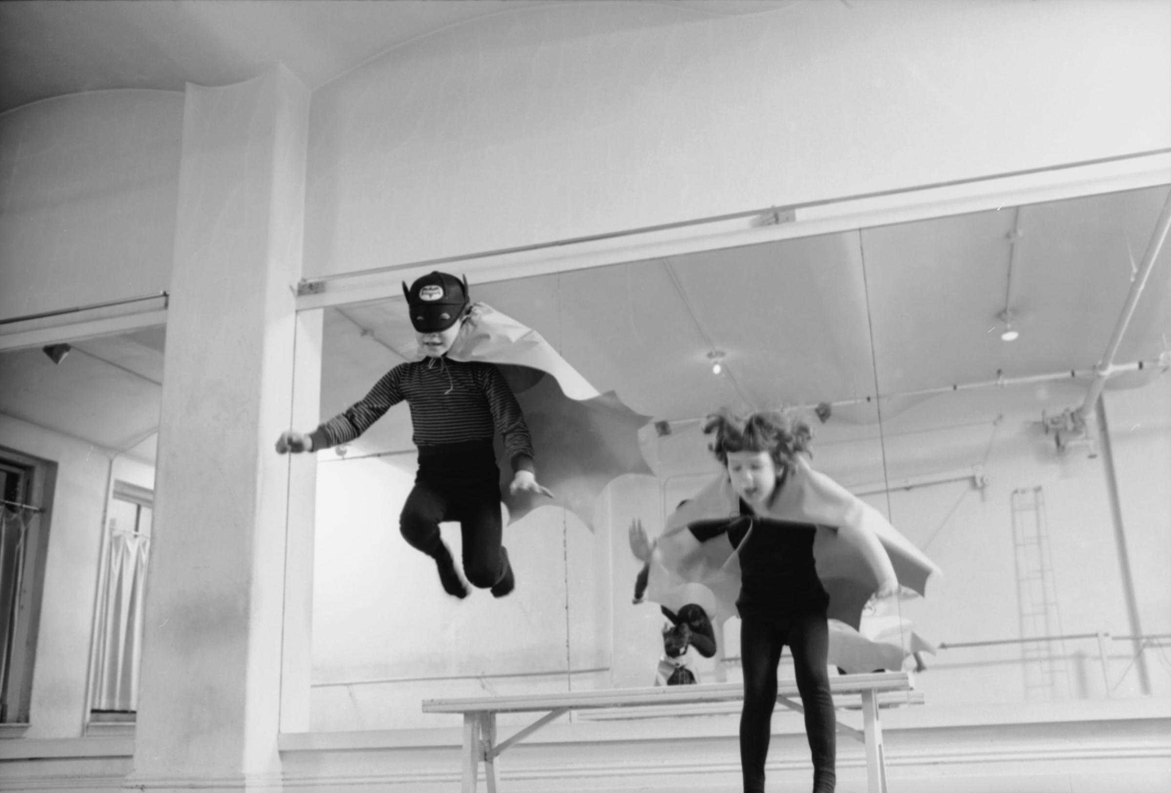 Two bat people, Colin Wightman, 6, and Kitty Blumberg, 4, of New York, leap into action.