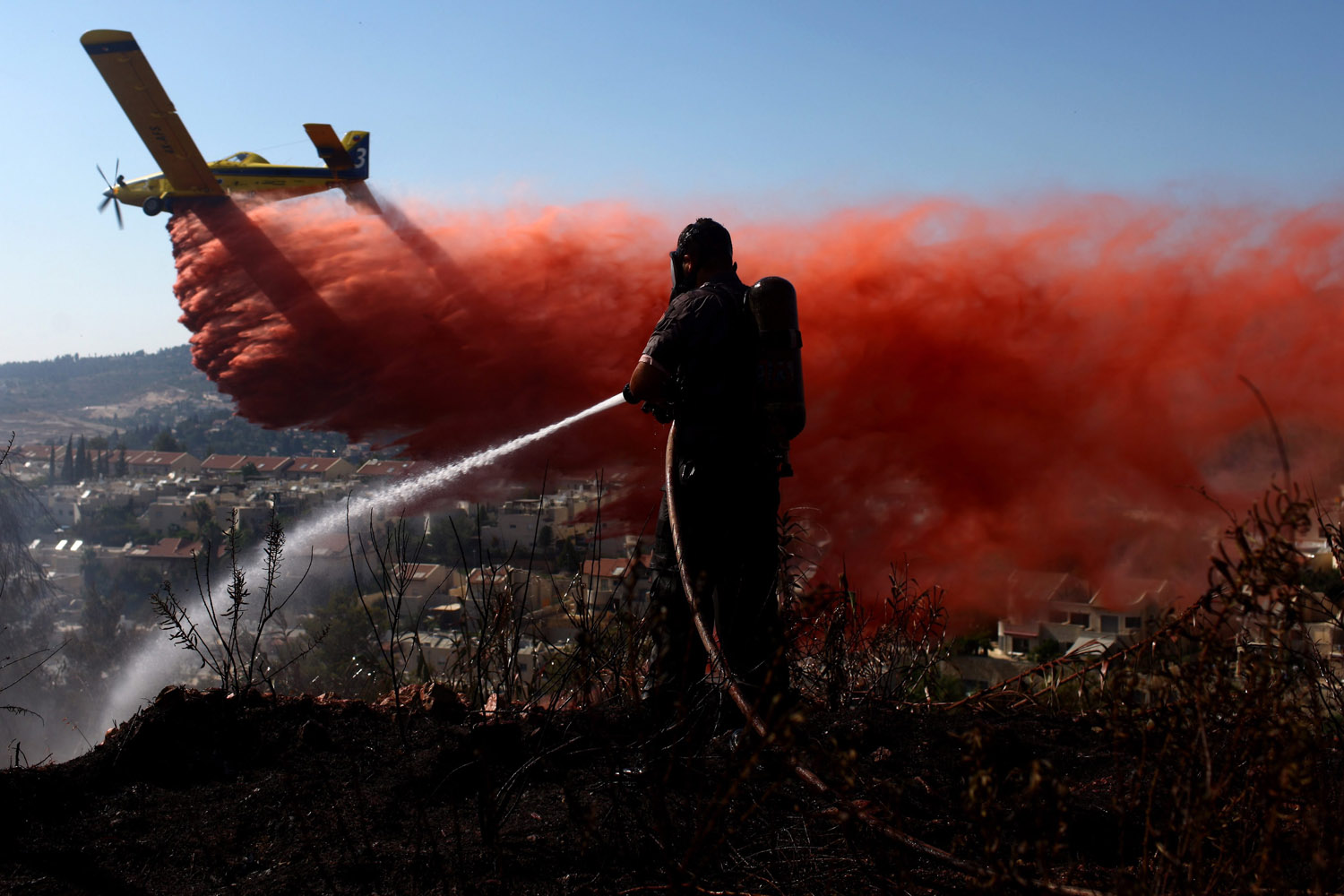 July 15, 2012. A firefighting plane drops retardant on a forest fire burning near Ein Hemed, west of Jerusalem, Israel.