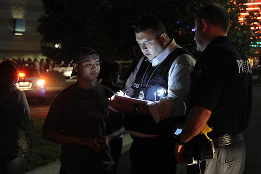 A police detective takes a witness statement following a shooting at the Century 16 movie theater in Aurora, Colo., early Friday morning July 20, 2012.