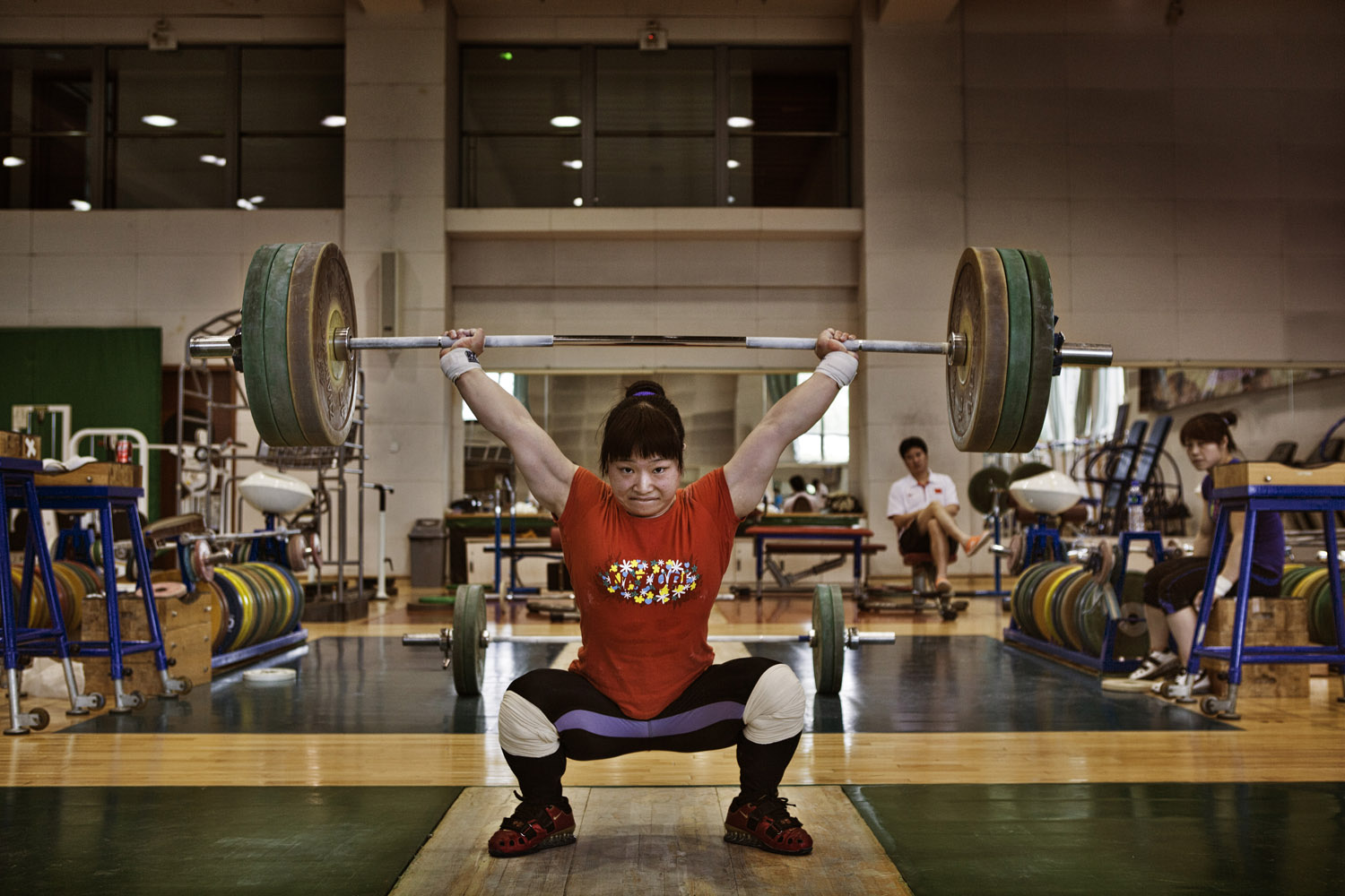 An athlete from the Chinese national women's weight-lifting team trains at the national sports training center in Beijing for a spot on the Olympic weight-lifting unit.