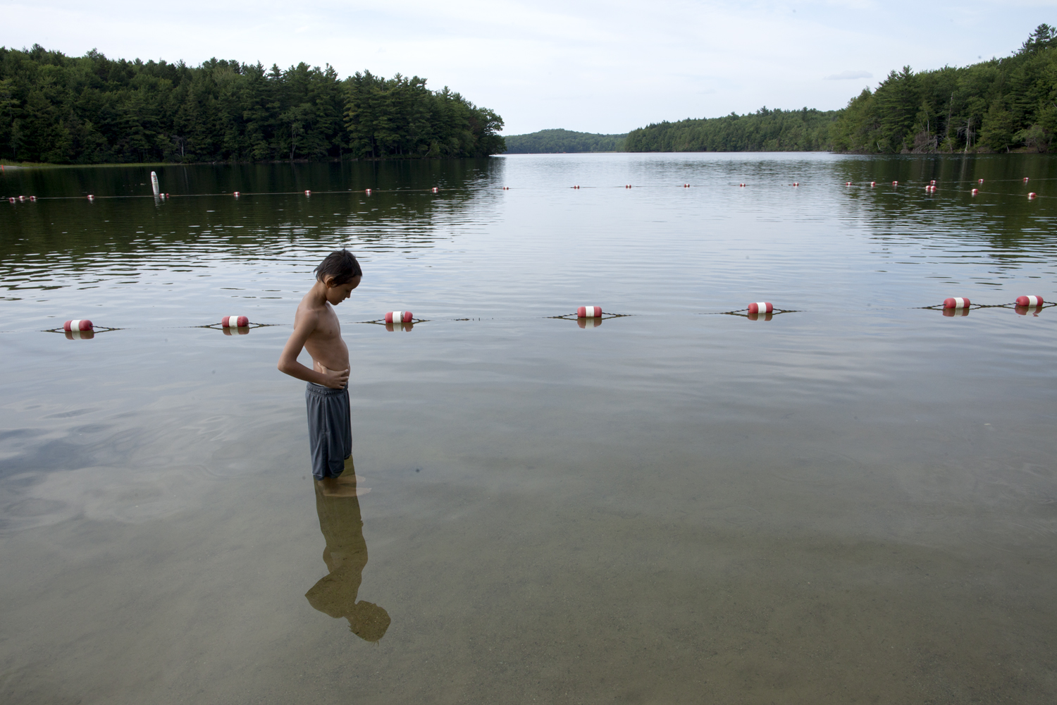 Donny stands in Grafton Lake waiting for fish to bite his feet. The fact that he is able to stand quiet and still–something that would have been inconceivable a year ago–is a testament to the special year-round school program that he has been attending since the winter. July 2012.