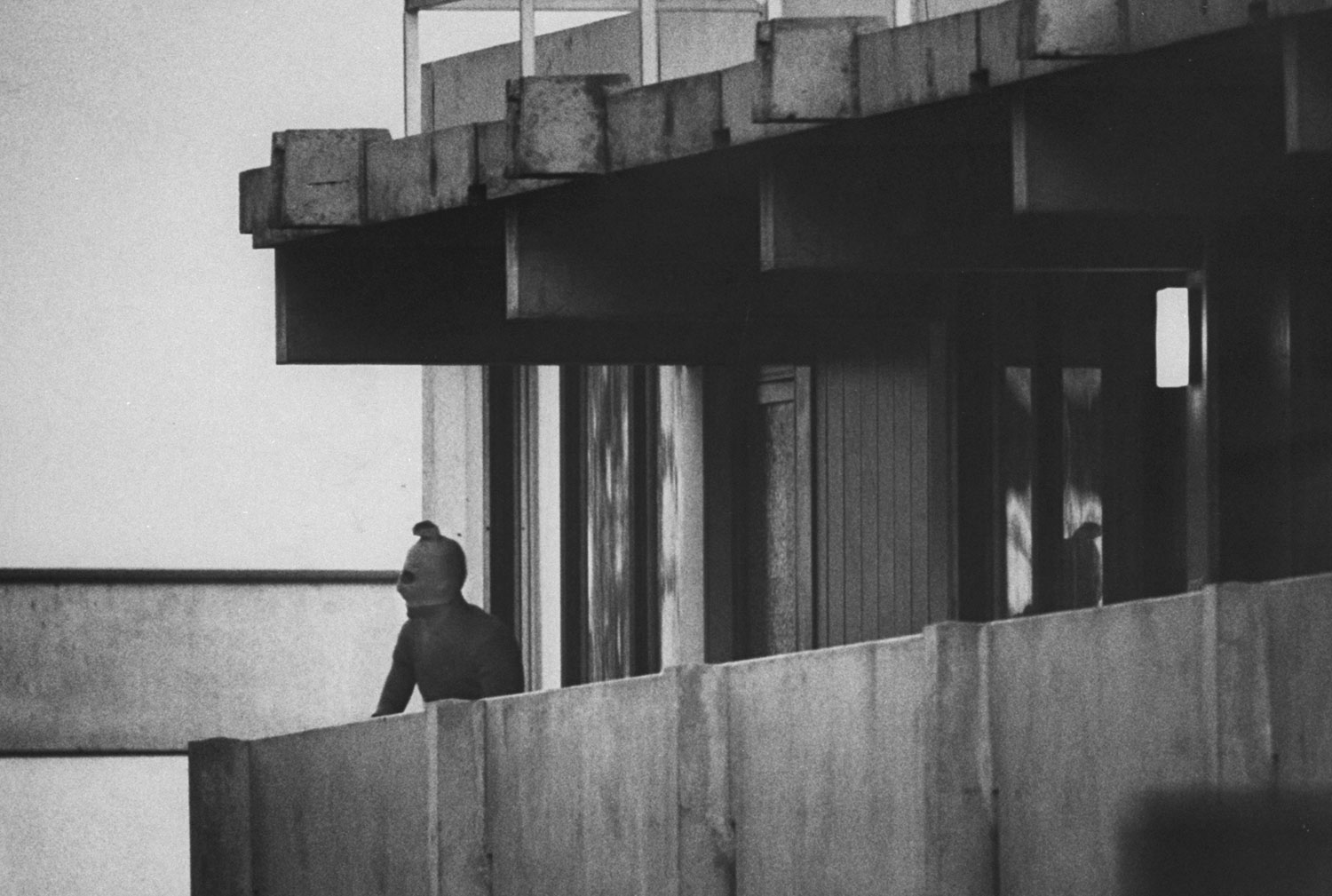 A Black September terrorist looks from the balcony of an apartment where Israeli Olympic team members are held hostage, Munich, September 1972. (Co Rentmeester—Time &amp; Life Pictures/Getty Images)