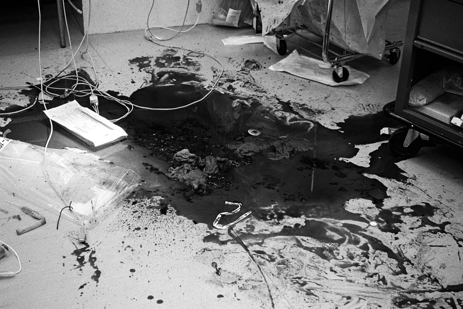 The aftermath of a chest gunshot wound treated in Emergency Room 1 at the Elvis Presley Memorial Trauma Center in Memphis. Paramedic Patricia Artella, from the ambulance radio communications room, says,  Have you ever seen them crack a chest? It's like a hog slaughter; blood on the walls, blood on the ceiling, half inch thick on the floor...