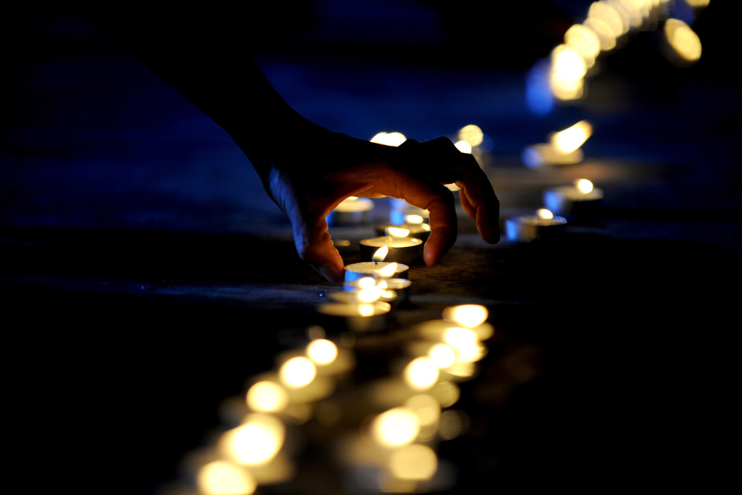 Aug. 19, 2012. A college student lights candles during a ceremony to mark the 1,000th day since a 2009 massacre that left 57 people, including journalists, dead, in Manila.