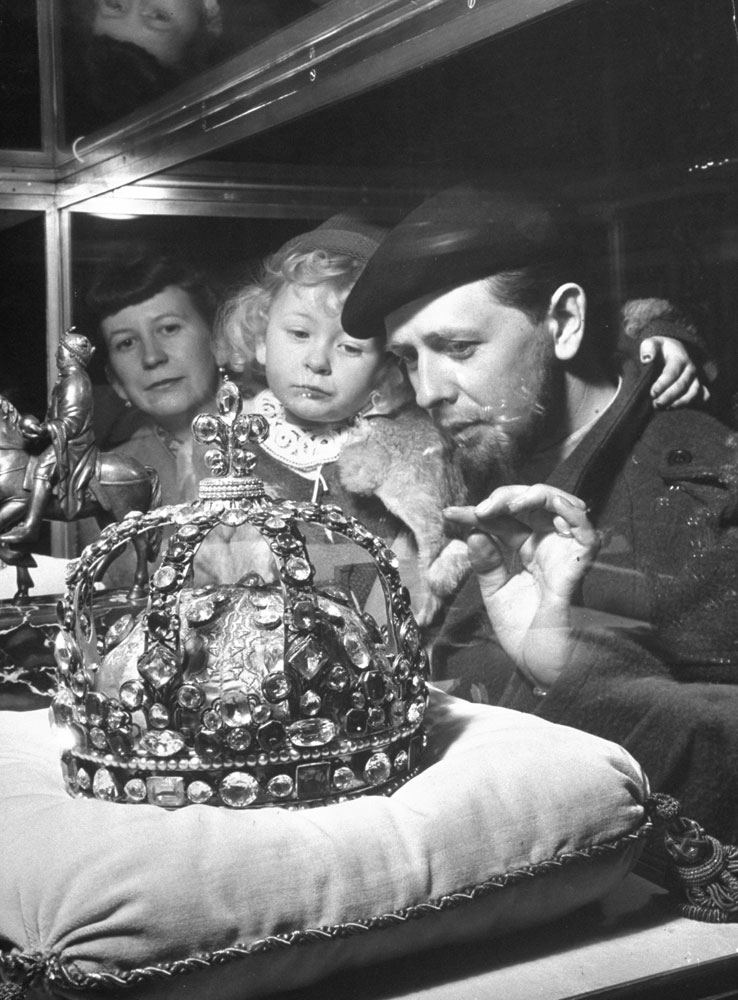 Married couple and their young daughter view the crown of King Louis XV at the Louvre, 1953.