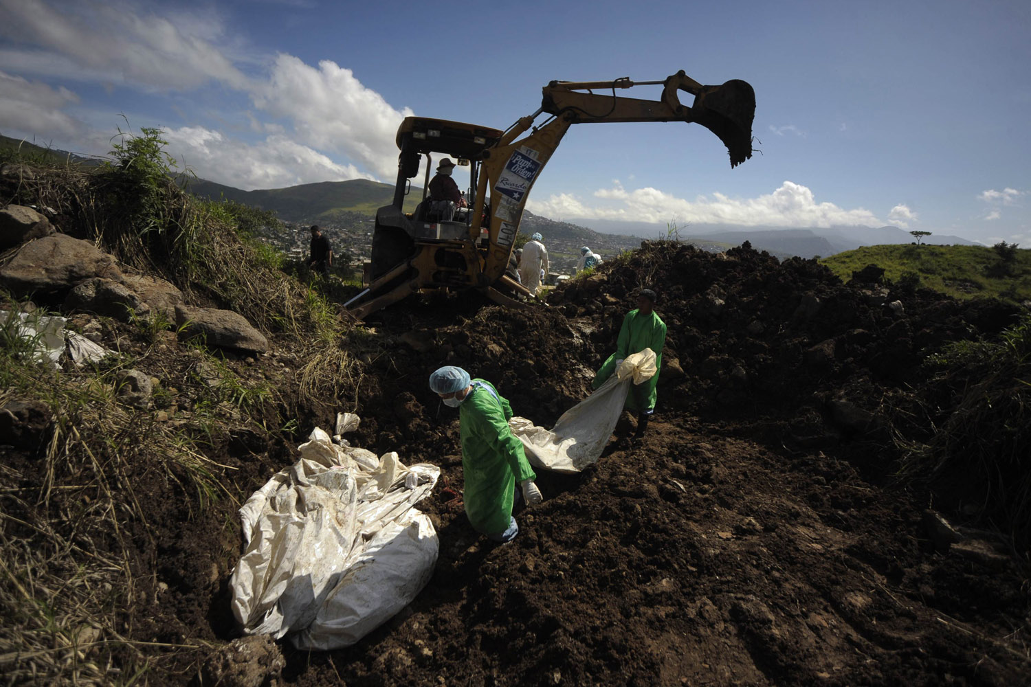 Aug. 18, 2012. Morgue workers carry a bag containing an unidentified body into a grave at Divine Paradise cemetery in Tegucigalpa.