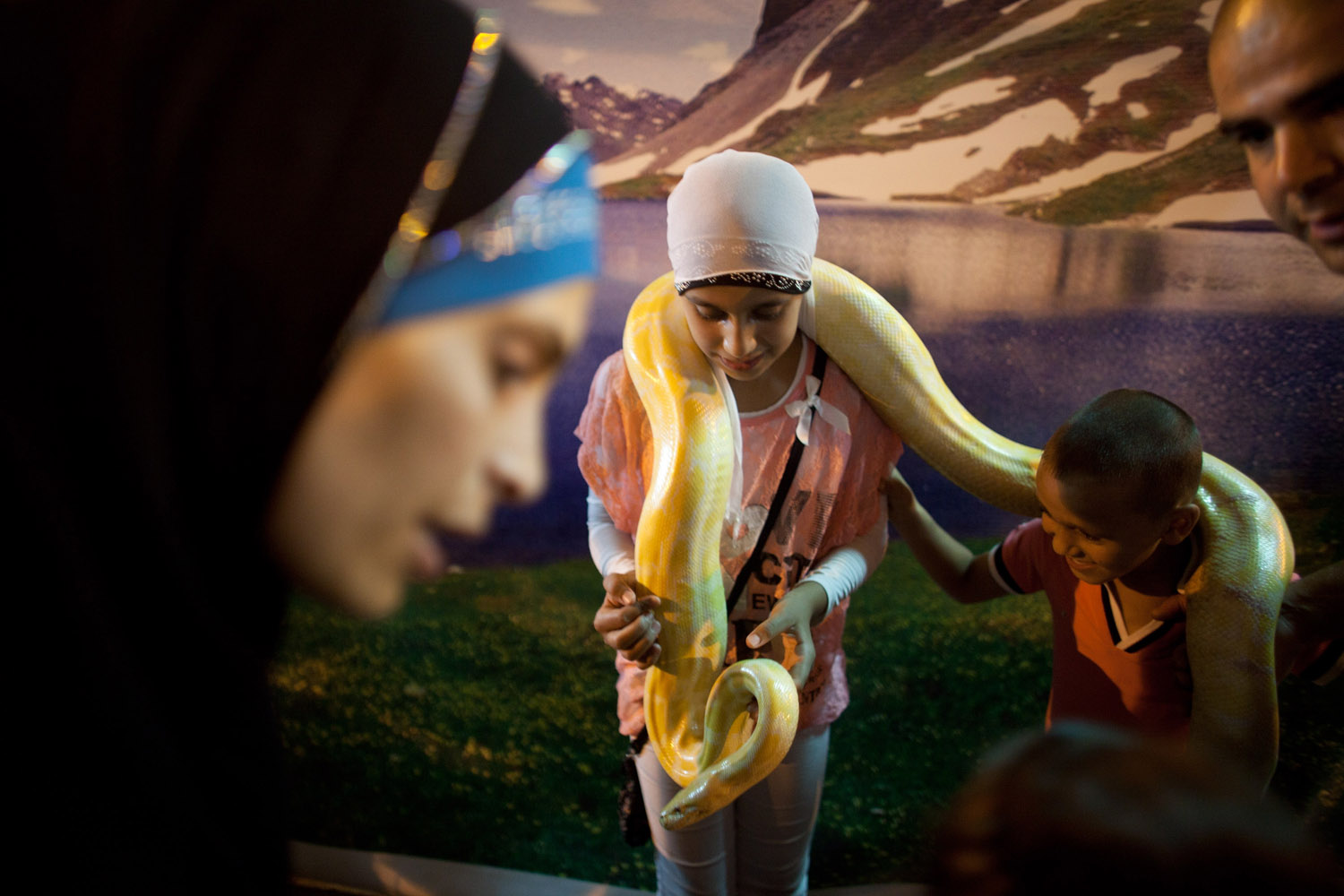 Aug. 20, 2012. Israeli Arabs get their picture taken with a pet snake at an amusement park as Muslims celebrated the Eid al-Fitr holiday, which marks the end of the holy fasting month of Ramadan in Acre, Israel.