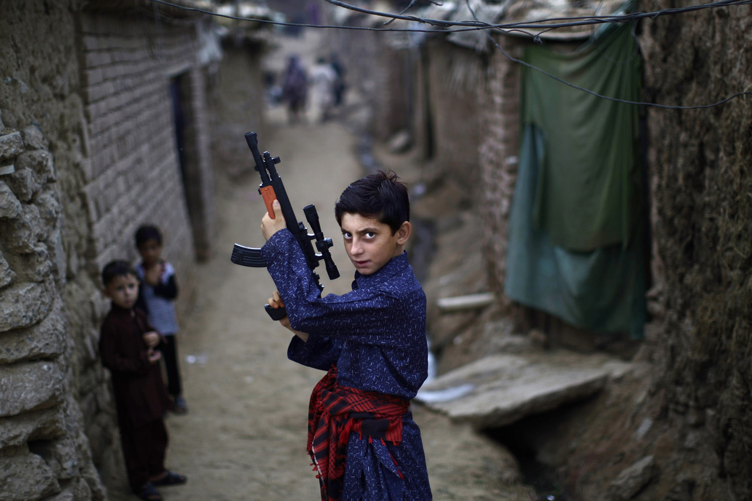 Aug. 20, 2012. A young Afghan refugee poses with a plastic rifle as he and other children celebrate the first day of the Eid al-Fitr festival, which marks the end of the Muslim fasting month of Ramadan, in a slum on the outskirts of Islamabad.