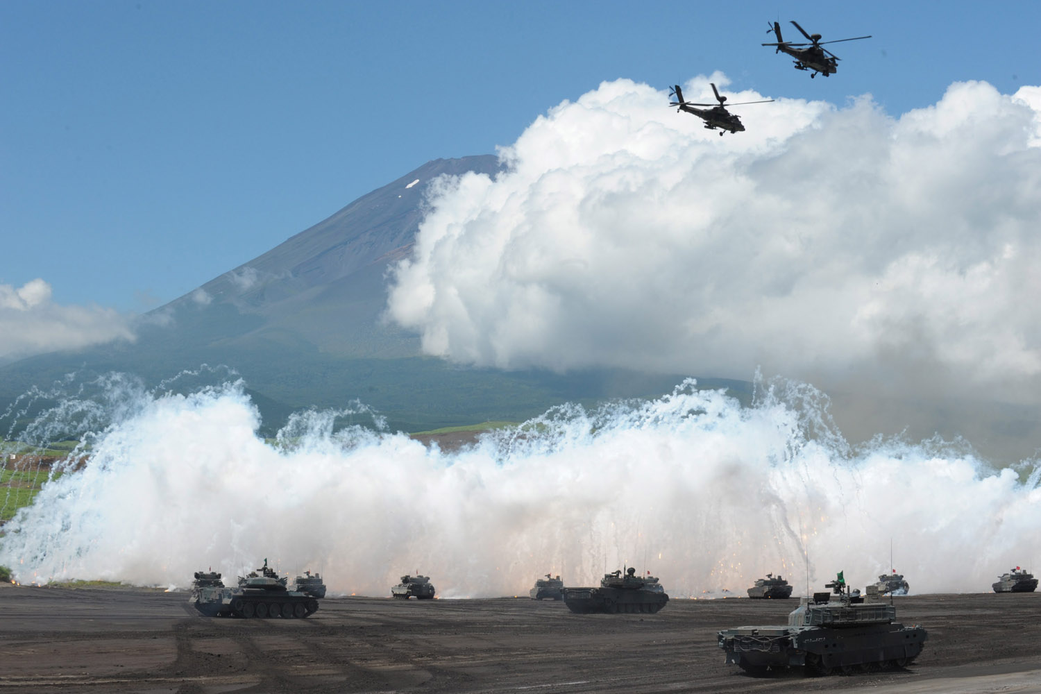 Aug. 21, 2012. Helicopters fly over a field as tanks fire a volley during the annual live fire exercise by the Japan Ground Self-Defense Force (JGSDF) at the foot of Mount Fuji in Gotemba, 100km southwest of Tokyo, Japan.