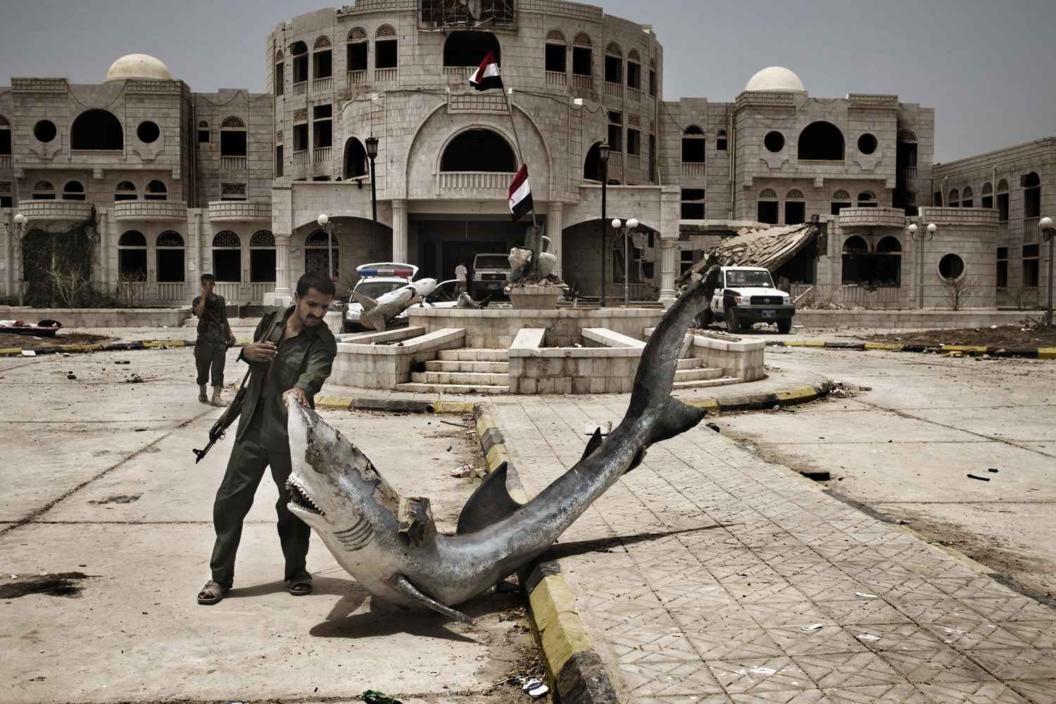 A Yemeni policeman retrieves a fixture of a destroyed water-fountain outside the Governor's Office in Zinjibar. Al-Qaeda in the Arabian Peninsula (AQAP) occupied a large swath of Abyan before being driven out by a combination of government troops, armed citizen groups and U.S. drone attacks.