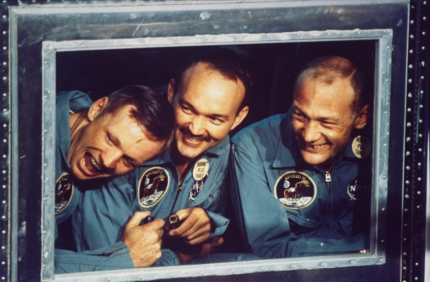 Apollo 11 astronauts Armstrong, Collins and Armstrong peer out the window of their quarantine room aboard the recovery ship Hornet following their return to Earth after historic mission to the moon, July 24, 1969.