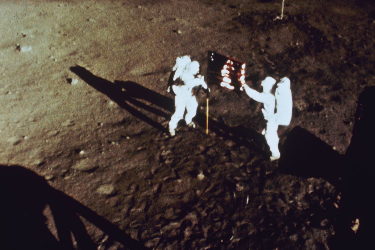 Apollo 11 astronauts Neil Armstrong and Buzz Aldrin plant the American flag on the moon, July 1969.