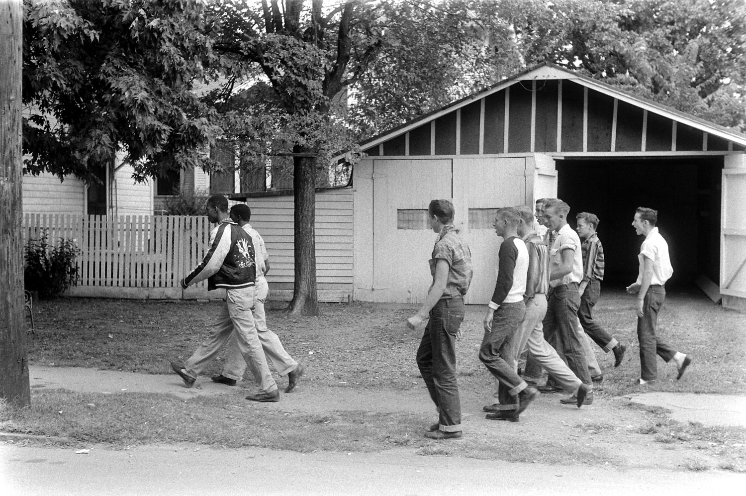 A group of jeering anti-integrationists trail two black students down a street in Little Rock, Arkansas, 1957.