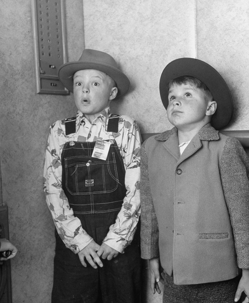 Two boys hold their breath, amazed, on their first elevator ride, 1948.