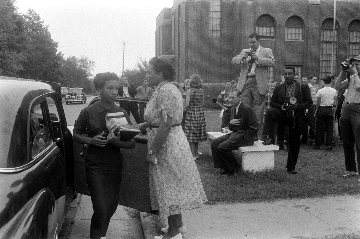 At a school in Van Buren, Arkansas, African-American students arrive in front of a crowd of journalists and other onlookers, 1957.