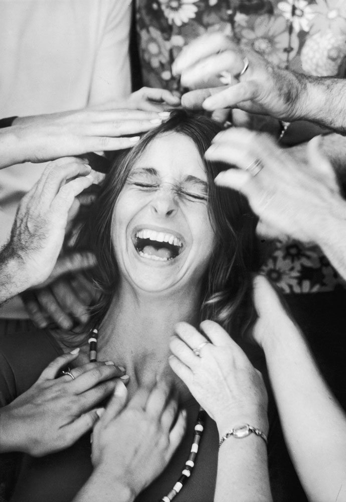 A woman laughs uproariously as she undergoes a "head-tapping session," part of a sensory awareness class in an encounter group at the Esalen Institute in 1970.