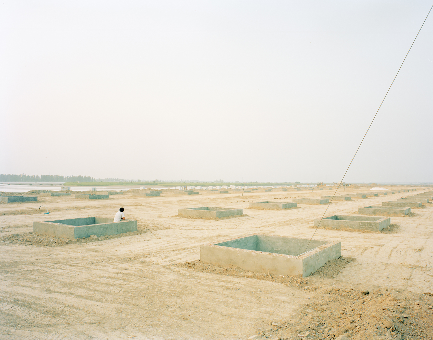 image: A worker in a construction site of the riverbank, Ningxia province.