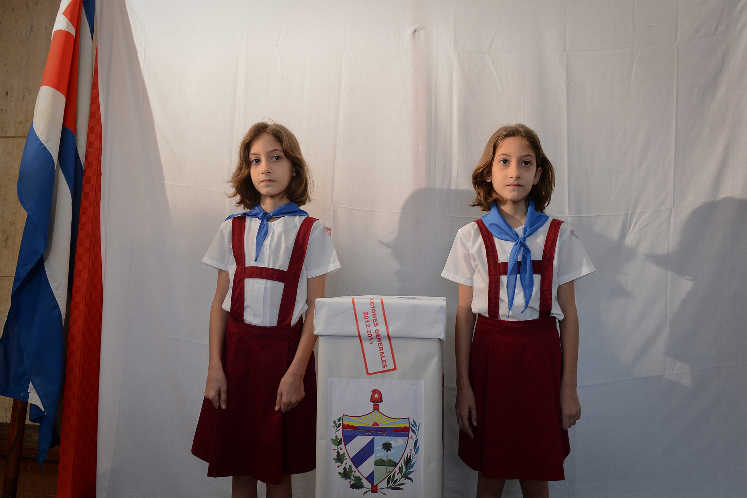 Image: Oct. 21, 2012. Two Cuban girls guard a polling station in Havana. Cubans lined up at polling stations Sunday for municipal elections in the one-party Communist-run island.