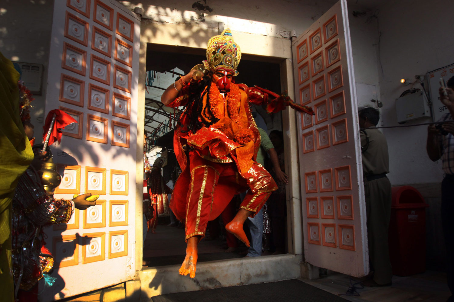 Image: Oct. 19, 2012. A Hindu devotee dressed as Hindu monkey god Lord Hanuman leaps through a doorway as he enters Lord Hanuman's temple during a religious procession of the Navratri festival in Amritsar, India.
